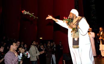 Shaykh Babikir throwing roses into the audience