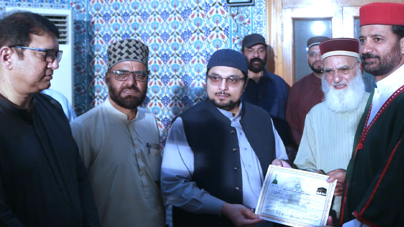 Dr. Hussain Mohi-ud-Din Qadri distributes souvenirs among residents of Gosha-e-Durood